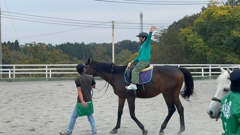 乗馬体験中のKAITOさん。楽しそうに片手でバンザイをしている