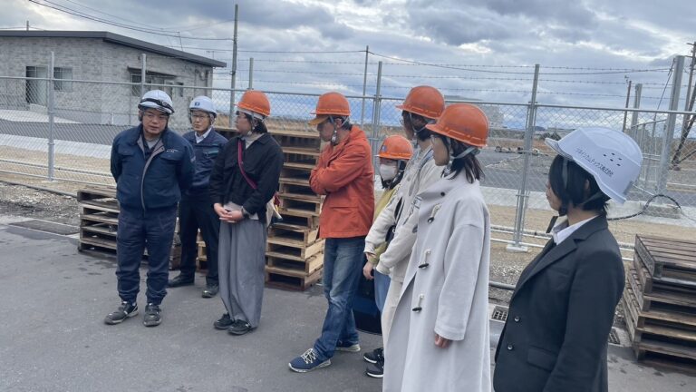 工場の敷地内で説明を聞いているところ