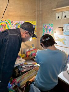 坂東社長に自分の絵について話すアーティスト・KAITO