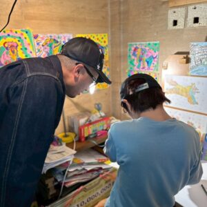 坂東社長に自分の絵について話すアーティスト・KAITO