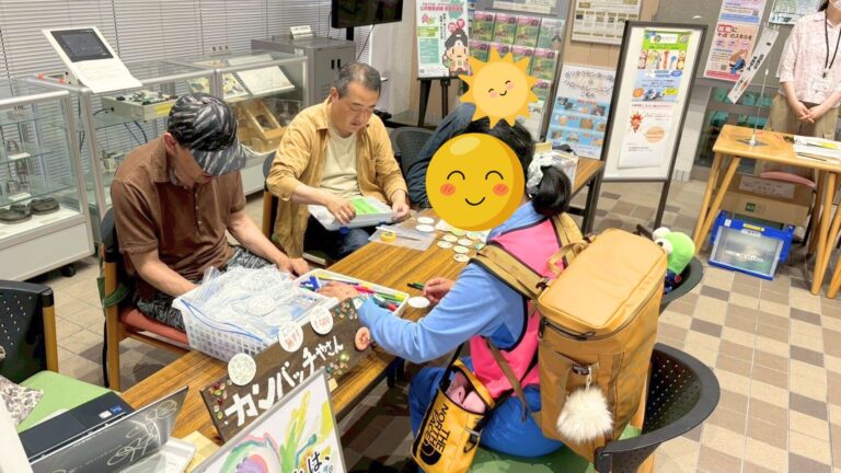 ワークショップのようす。缶バッジを作る参加者とハブラボ講師たち