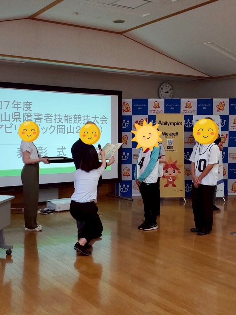 表彰式の様子。表彰状を読み上げられているIdoさん
