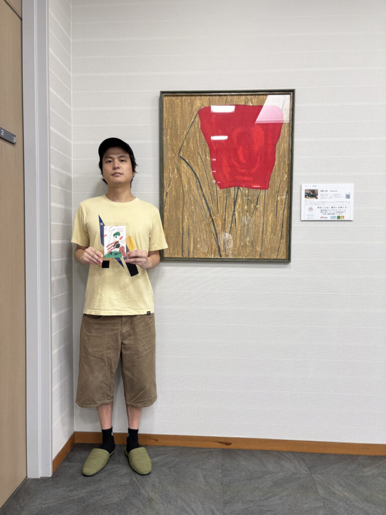 絵の前でサンクスカードを持ってうつる伊藤士隼