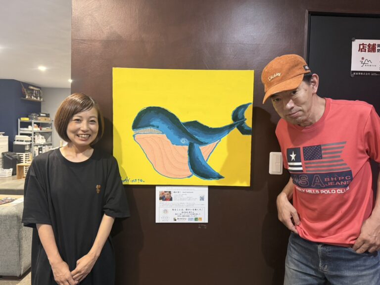 納品した作品「くじら」のとなりに立っているアーティスト・橋本賢二と美巧の方