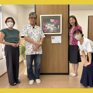 納品した作品の前で笑顔で写るアーティスト・川上岳史と中川事務所の方3名。