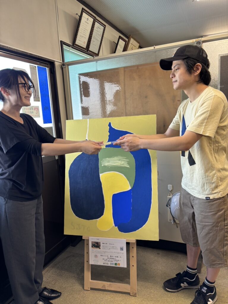 港湾運送の方にサンクスカードを手渡すアーティスト・伊藤士隼