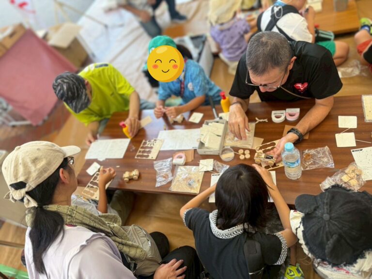 ミニカー工作のようす　岡山ダイハツ・杉野さんがこどもたちに教えている
