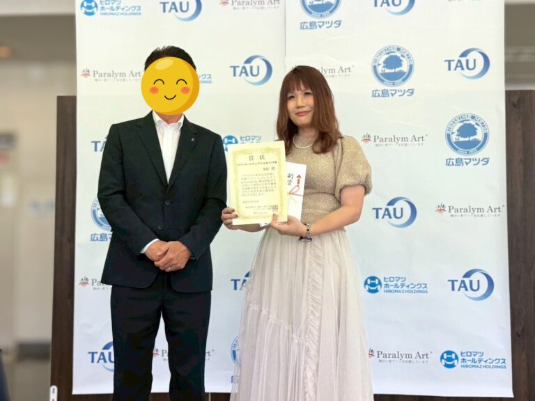 広島マツダ山根社長(左)とアーティスト・Rie(右)手には表彰状で笑顔