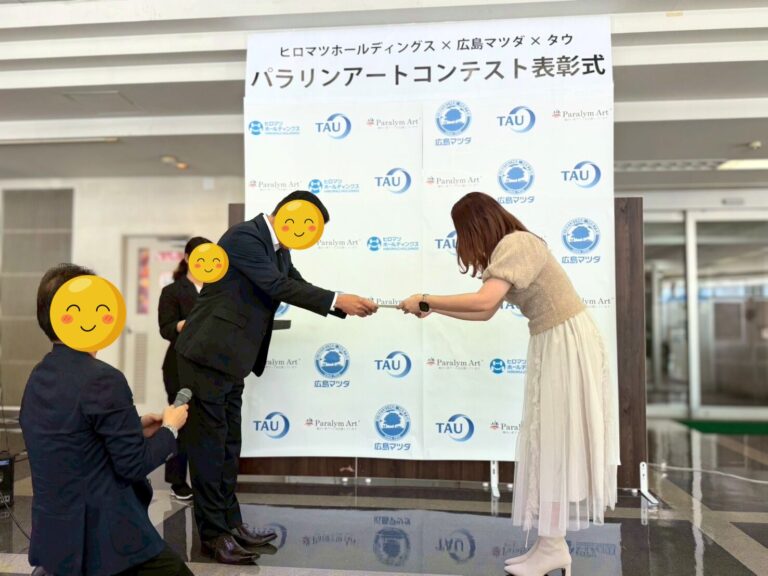 表彰状を広島マツダ山根社長(左)から受け取るアーティスト・Rie(右)