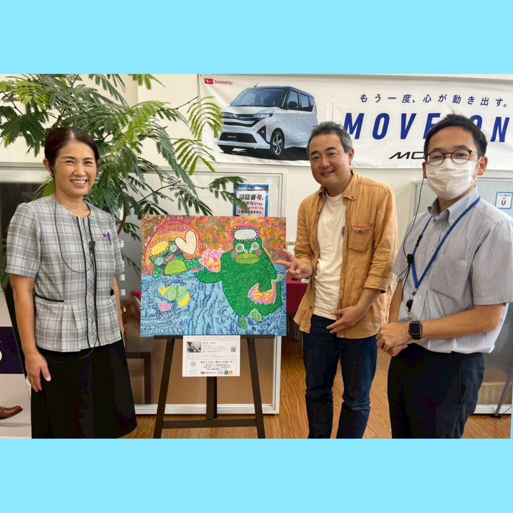 納品した作品（アート・カナピ作）と岡山ダイハツ倉敷中央店の方とアーティスト・下村良作