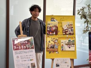 納品した自分の作品とその横に立つアーティスト・miya
