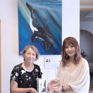 納品した作品の前で笑顔で写るアーティスト・Rieと株式会社スパーキーの方