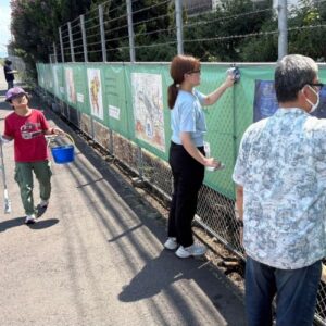 バケツを持って運ぶアーティスト・KAITO、アートウォールをする山口マネージャー、アーティスト・川上岳史