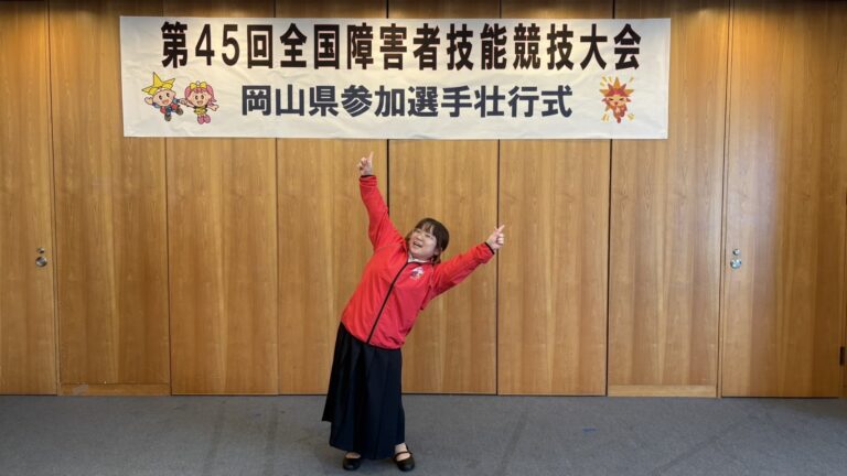 横断幕の下でポーズをとるろりちゃん