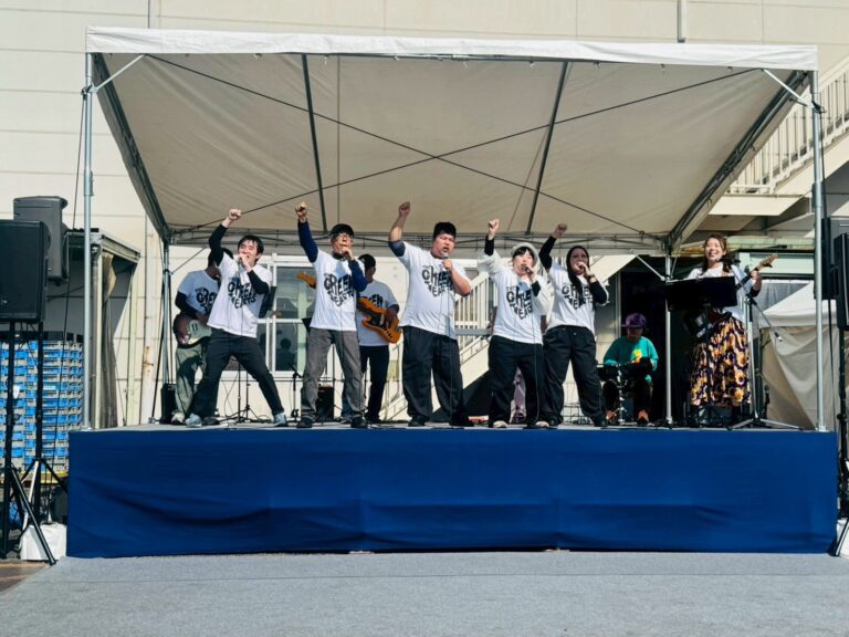 ライブの様子 ボーカル隊は右手のこぶしを次挙げている 全員笑顔