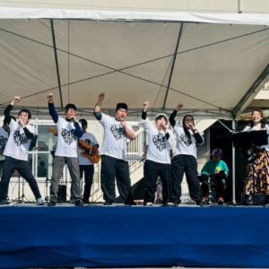 ライブの様子 ボーカル隊は右手のこぶしを次挙げている　全員笑顔