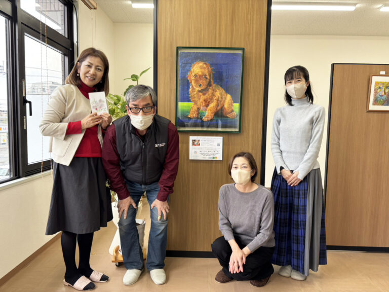 納品したアーティスト・川上岳史の作品「ぼくんちのプードル」を囲んで記念撮影（川上岳史と中川事務所のみなさん）