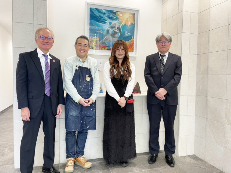 納品した作品の前で笑顔で写る中国製油のお二方とアーティスト・下村良作とアーティスト・Rie