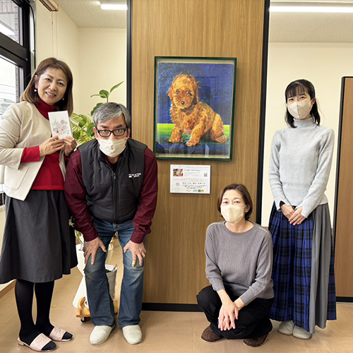 納品したアーティスト・川上岳史の作品「ぼくんちのプードル」を囲んで記念撮影（川上岳史と中川事務所のみなさん）