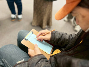 アーティスト・橋本賢二俳句を用紙に書いているようす