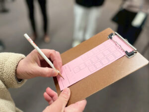 俳句を用紙に書き込むアーティスト・土肥ヨシの手元