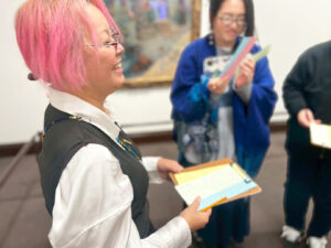 グループの中でなにかを楽しそうに話しているメンバー・レイチェル。奥にはアーティスト・呉飛瑶