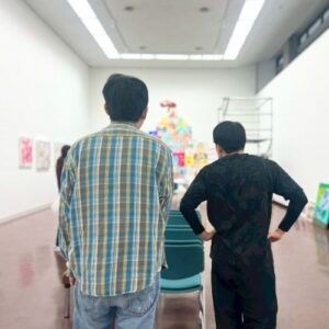 できあがったアーティスト・りょう展示を見ているりょうともう一方の後ろ姿