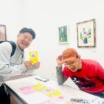 アーティスト・橋本賢二(右)からサンクスカードを受け取ったパートナー企業の方(左)