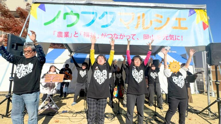 熱唱するグリーンハーツ① 腕を大きく上にあげて手を振っている