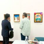 自分の作品をパートナー企業の方(左)に見てもらいながら話すアーティスト・下村良作