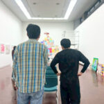 できあがったアーティスト・りょう展示を見ているりょうともう一方の後ろ姿