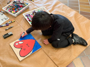 木の板にハートの絵を描いている