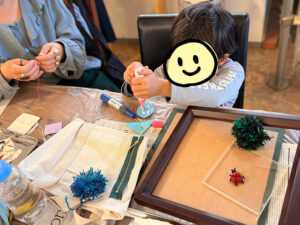 制作の様子、木工用ボンドを力いっぱいにぎって出しているところ