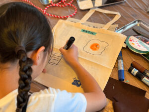 トートバッグに絵を描いているようす右上に目玉焼きの絵