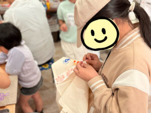 トートバッグに刺繍リボンを縫い付けているところ