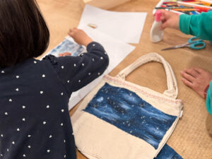 トートバッグ制作中のようす。夜空柄の布をくっつけている