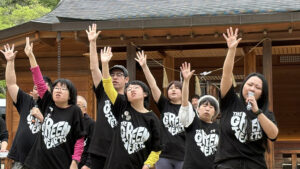 右手を上におおきくあげて歌うグリーンハーツ